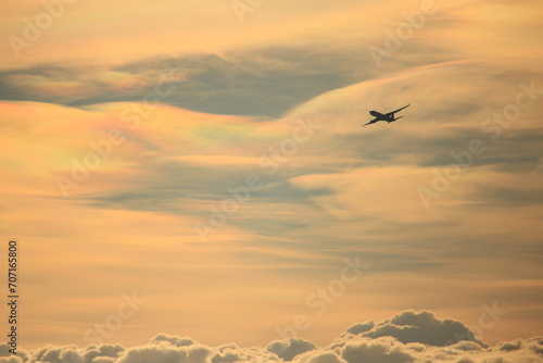 taking off airplane in front of iridescent clouds © Marcel