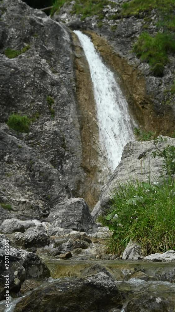 Vertical shot of rocks, a waterfall and a mountain stream, overcast Vertical shot of rocks, a waterfall and a mountain stream, overcast