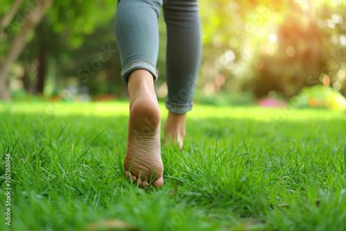 Woman walking on green grass in park, closeup. Healthy lifestyle