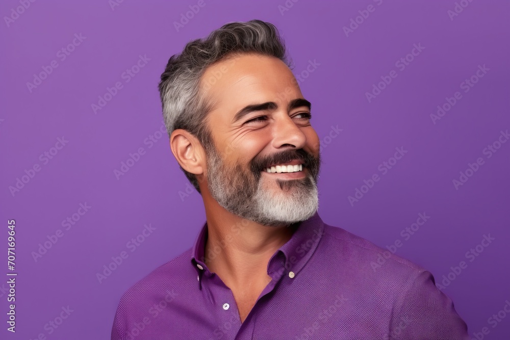 Portrait of handsome middle-aged man with grey hair and beard smiling at camera. Isolated on purple background Portrait of handsome middle-aged man with grey hair and beard smiling at camera. Isolated on purple background