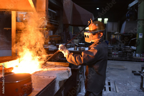 young worker in protective clothing at work at the blast furnace in an iron foundry © industrieblick