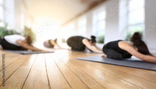 Young people practicing yoga in gym, focus on foreground, blurred background