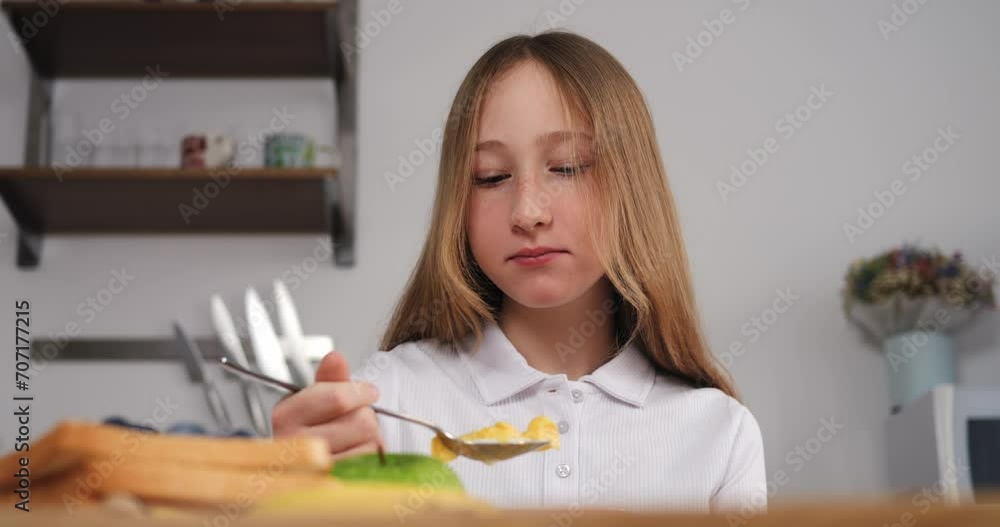 Girl in white shirt savors nutritious cereal and milk cinematic close-up shoot girl's breakfast is peaceful caring ritual at home. For girl such mornings foster sense of safety and well-being. Girl in white shirt savors nutritious cereal and milk cinematic close-up shoot girl's breakfast is peaceful caring ritual at home. For girl such mornings foster sense of safety and well-being.