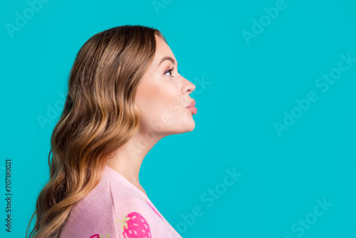 Side profile photo of young coquette girlfriend plump lips sending air kiss empty space learning flirt isolated on blue color background photo