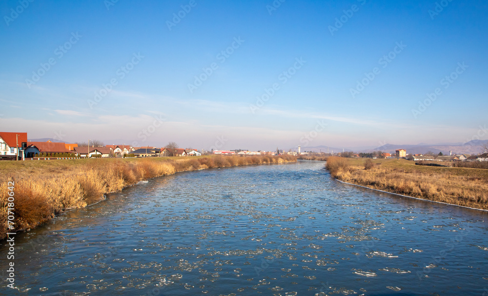 Mures River with pieces of ice floating on the surface flowing through the town of Reghin Mures River with pieces of ice floating on the surface flowing through the town of Reghin