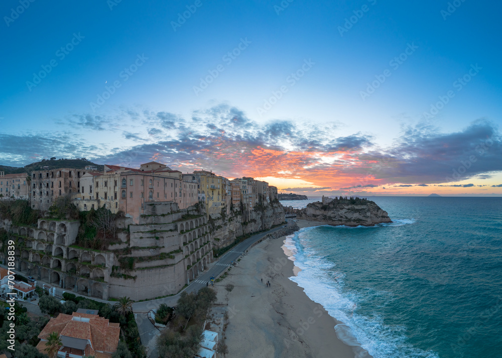 view of Rotonda Beach and the colourful old town of Tropea in Calabria at sunset