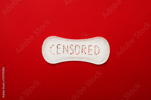 Hygienic pad with written word censored on red background photo