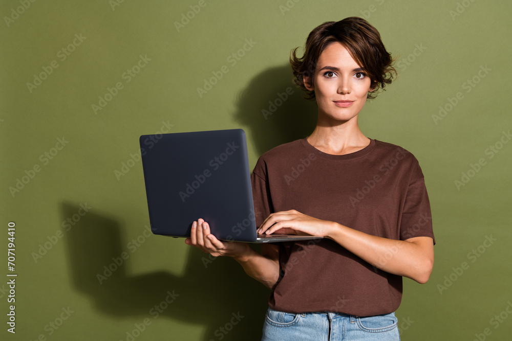 Photo portrait of lovely young lady hold netbook marketer working remotely wear trendy brown garment isolated on khaki color background Photo portrait of lovely young lady hold netbook marketer working remotely wear trendy brown garment isolated on khaki color background
