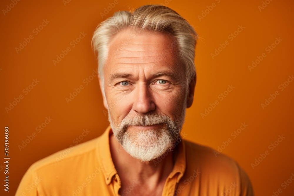 Portrait of a senior man with grey beard on orange background. Portrait of a senior man with grey beard on orange background.
