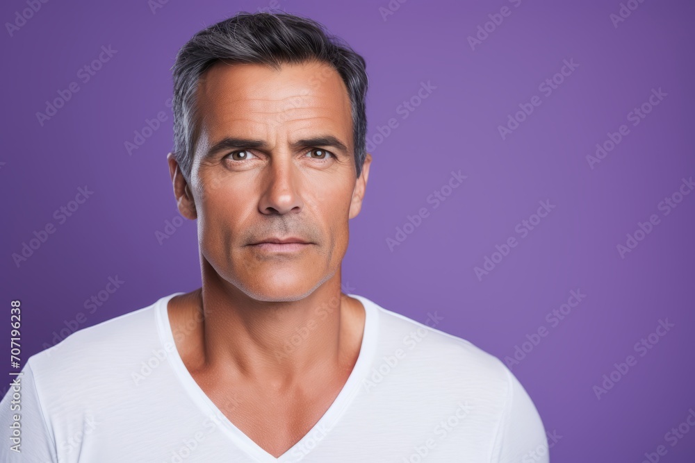 Portrait of handsome mature man in white t-shirt on violet background Portrait of handsome mature man in white t-shirt on violet background