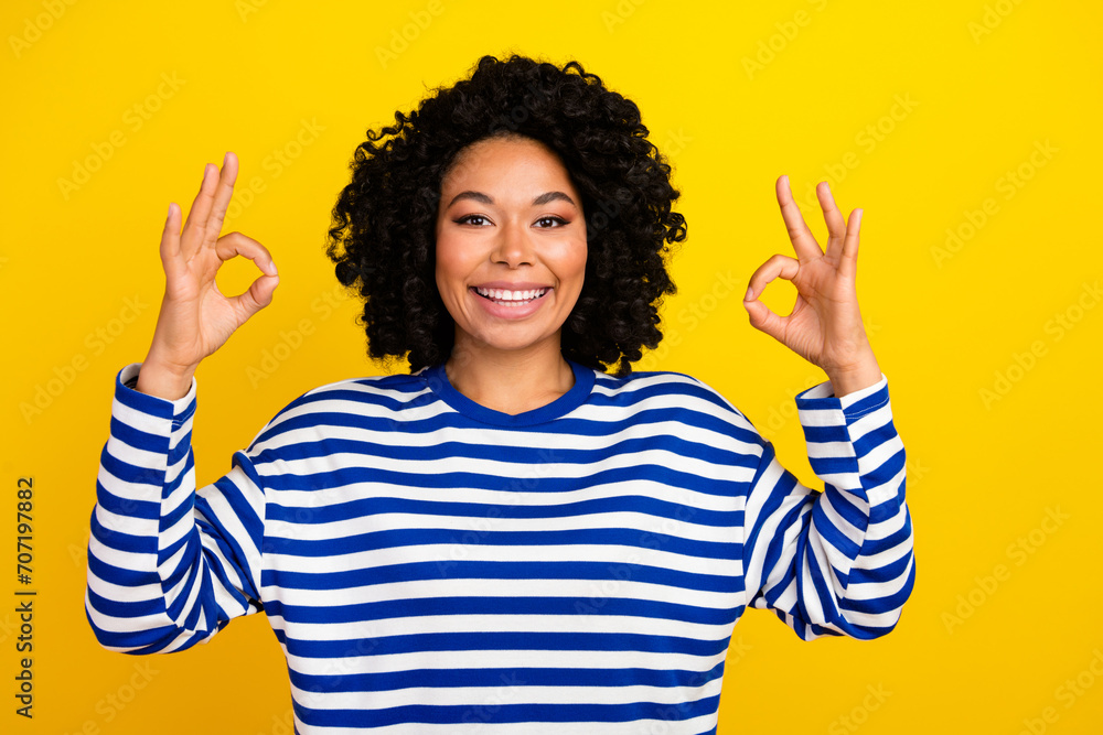 Photo of adorable cheerful satisfied woman wear stylish sailor clothes recommendation okey sign isolated on vivid yellow color background Photo of adorable cheerful satisfied woman wear stylish sailor clothes recommendation okey sign isolated on vivid yellow color background
