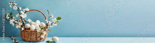 Osterkorb mit Eiern und Kirschblüten, Weidekätzchen isoliert vor blauem Hintergrund 
