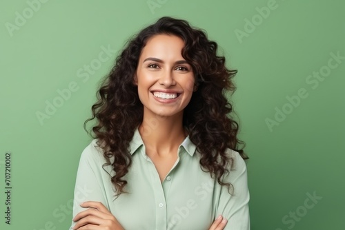 Portrait of happy smiling young woman with curly hair, over green background