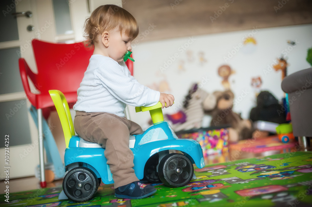 A toddler bursts with excitement as they ride a toy car across a vibrant rug, embarking on a thrilling and imaginative journey. A toddler bursts with excitement as they ride a toy car across a vibrant rug, embarking on a thrilling and imaginative journey.