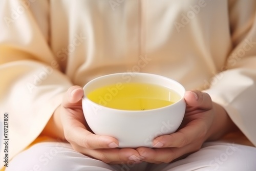 Young woman hands holding aromatic teacup cup of green leaves tea hot steaming beverage morning comfy comfortable breakfast drinking warm refreshing herb natural drink home rest steam aroma liquid