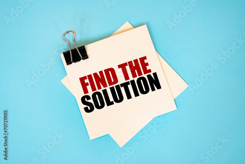 Text FIND THE SOLUTION, on sticky notes with copy space and paper clip isolated on red background. Finance and economics concept.