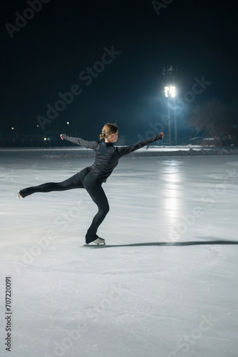 Beautiful young woman ice skating and performing short program