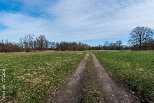 Springtime countryside with meadow, trail and trees around near Ostrava city in Czech republic
