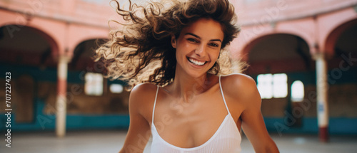 Beautiful young woman with curly hair is smiling and looking at camera .