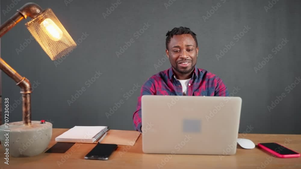 Online briefing of african american man sitting in workplace looking at laptop. Online briefing of african american man sitting in workplace looking at laptop.