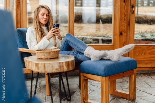 Woman at Cozy Terrace Text Messaging on Smartphone