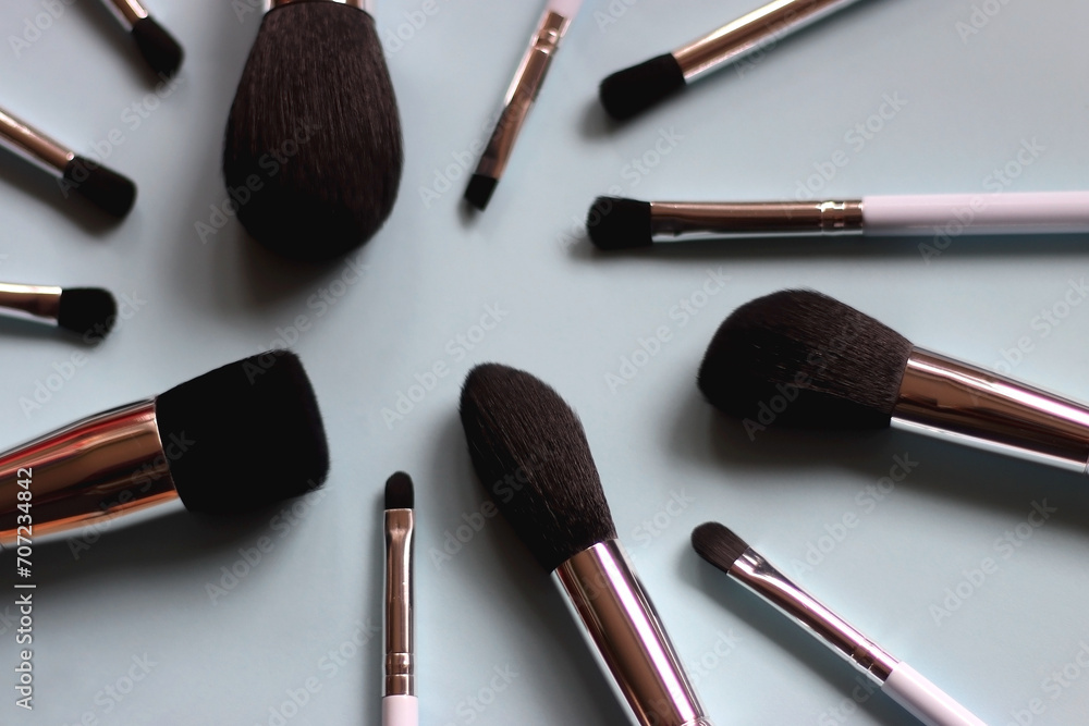 Various make up brushes on bright blue background. Selective focus. Various make up brushes on bright blue background. Selective focus.