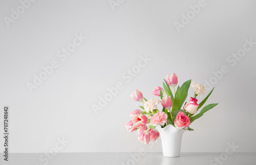 Fototapeta Naklejka Na Ścianę i Meble -  pink spring flowers in white ceramic vase in modern home interior