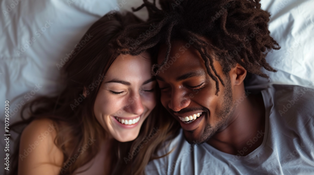 Happy couple, bed and laughing in relax for morning, bonding or intimate relationship at home. Interracial man and woman smiling with laugh in joyful happiness or relaxing weekend together