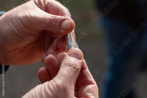 Man s hands rolling a cigarette  the paper on the tobacco