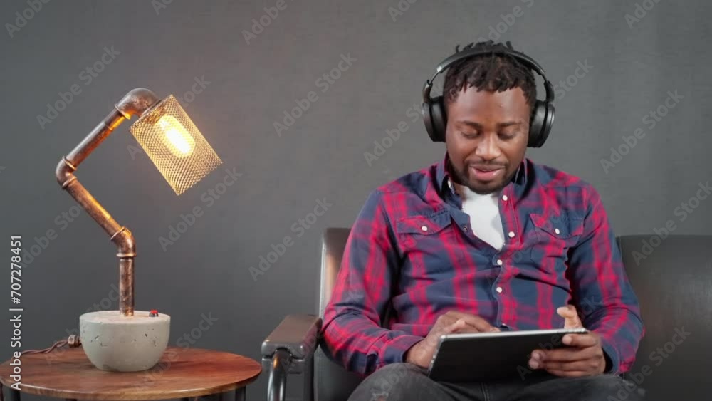 african american man singing along favorite song when listening it by headphone, surfing internet african american man singing along favorite song when listening it by headphone, surfing internet