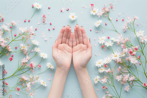 Woman hands among the spring flowers. Floral background with beautiful female hands. Natural cosmetics and skin care concept