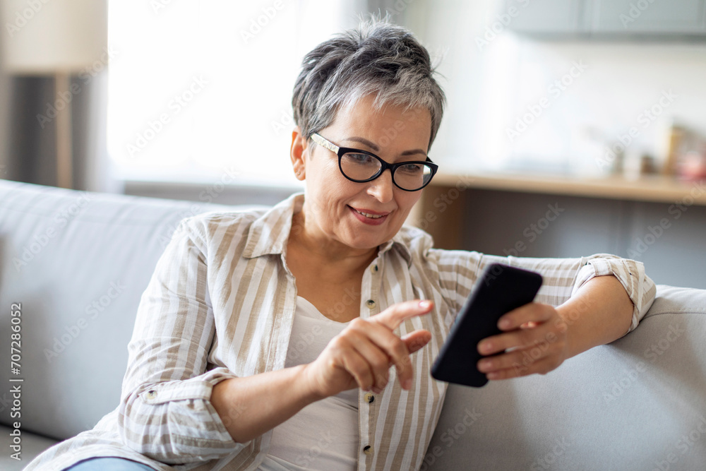 Great App. Senior Woman Using Smartphone While Sitting On Couch At Home Great App. Senior Woman Using Smartphone While Sitting On Couch At Home