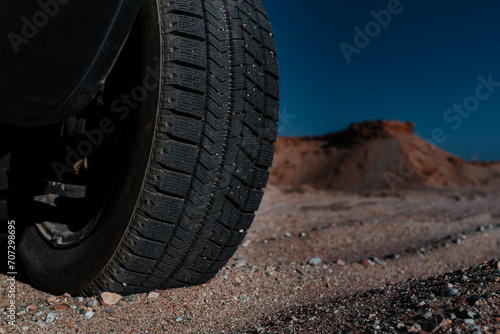 Car wheel on sand in the mountains close-up view © chaossart