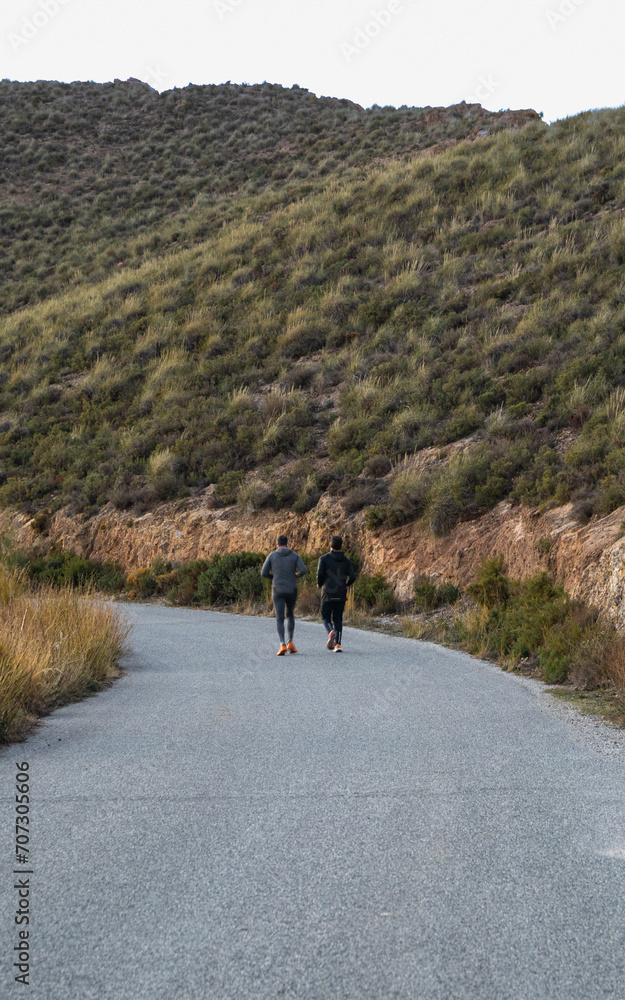 Obraz premium Two men jogging, running on a slope, Spain, Andalusia