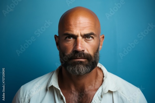 Portrait of a bald man with a beard on a blue background