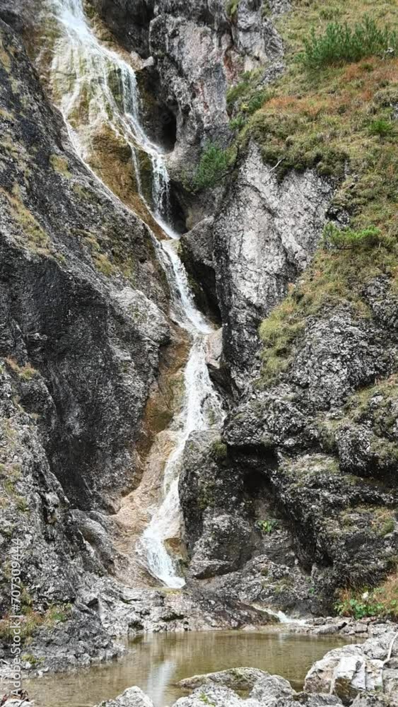 Vertical shot of a stepped waterfall in autumn, autumn colors, autumn colors, overcast, slow motion Vertical shot of a stepped waterfall in autumn, autumn colors, autumn colors, overcast, slow motion
