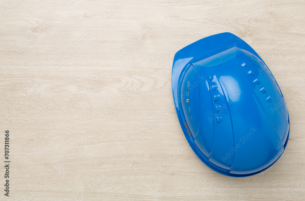 Blue construction helmet on wooden background, top view Blue construction helmet on wooden background, top view