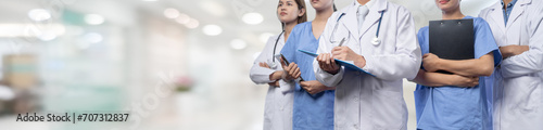 Confident medical staff team with doctor nurse and healthcare specialist professions people in blurry hospital corridor background. Medical and healthcare community in panoramic banner. Neoteric photo