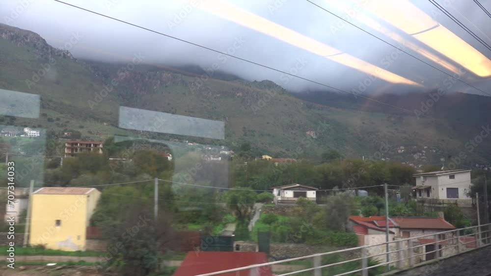 Palermo, Sicily, Italy A woman sitting on a moving train enjoys the view of the countryside from the window seat. Palermo, Sicily, Italy A woman sitting on a moving train enjoys the view of the countryside from the window seat.