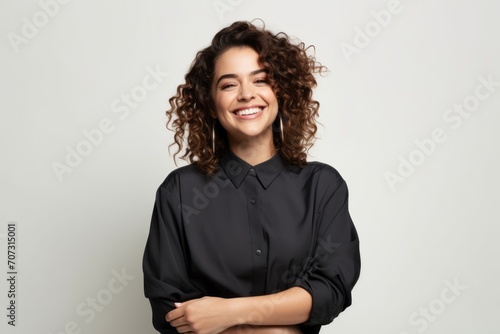 Portrait of a smiling young woman with curly hair in black shirt