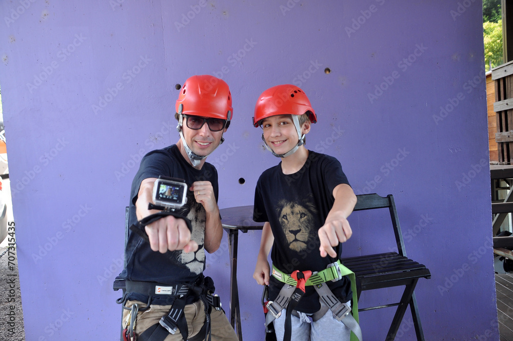 Fototapeta premium pai e filho com equipamentos para atividade esportiva de tirolesa 