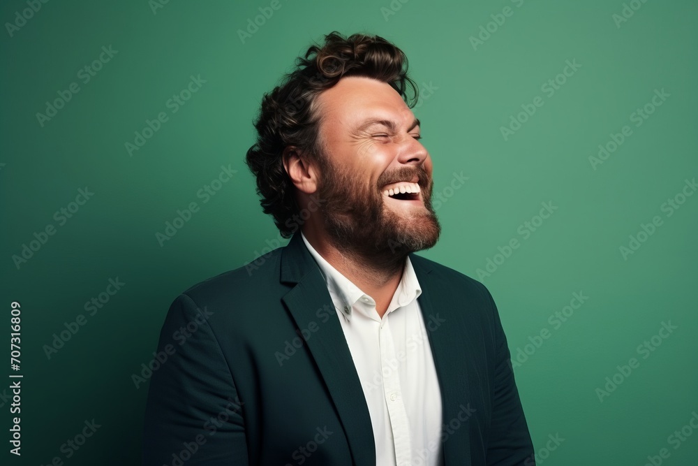 Portrait of a handsome young man laughing against a green background. Portrait of a handsome young man laughing against a green background.