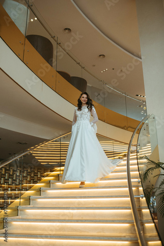 young girl bride in a long wedding dress goes to meet the groom photo