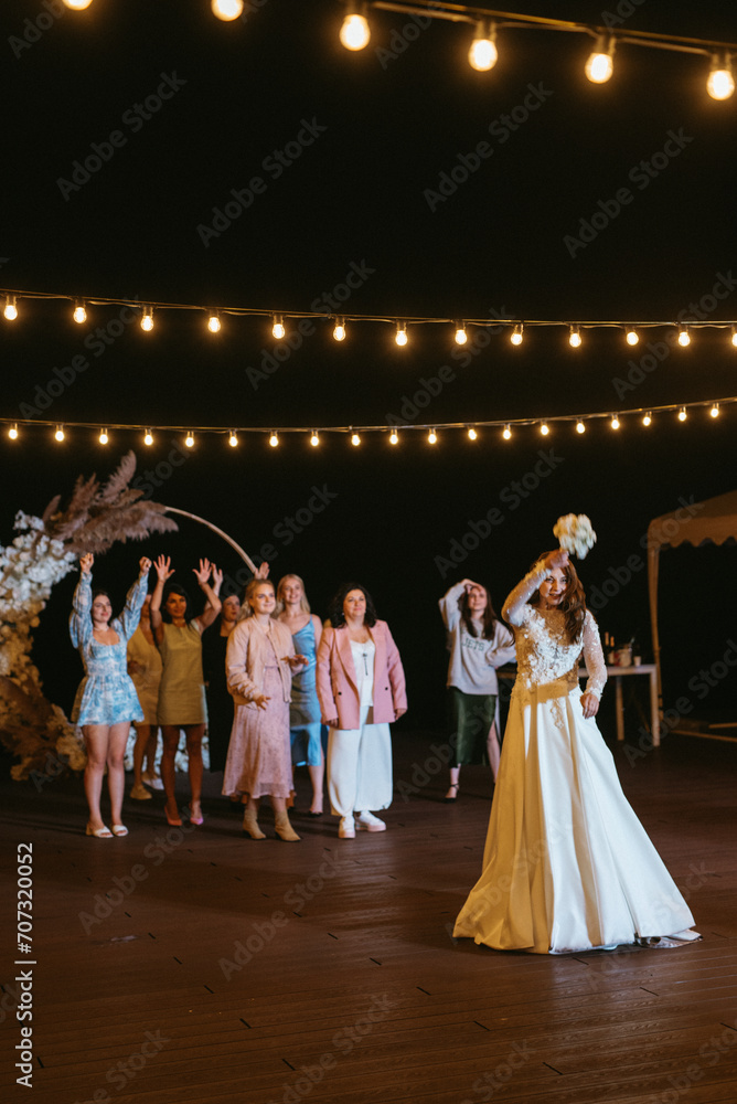 bride in a white dress throws a wedding bouquet