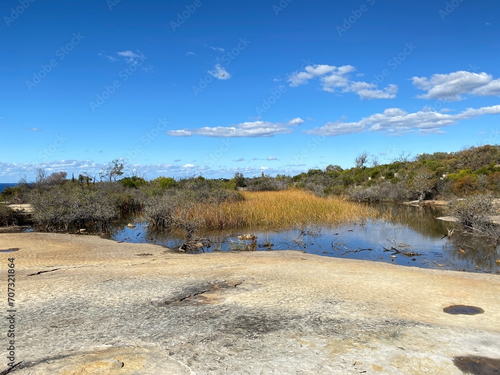 Lake in the mountains. Dry vegetation and rock formation at the summit. Desert rocky plateau. Views from a mountain-top lookout. Australia, Sydney.