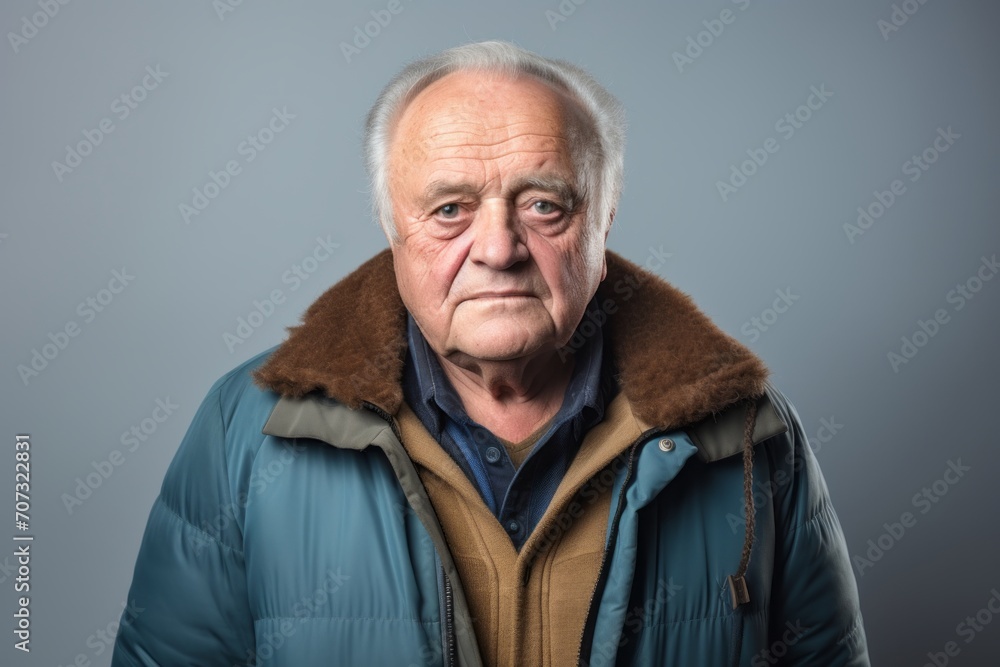 Portrait of an old man with a jacket on a grey background Portrait of an old man with a jacket on a grey background