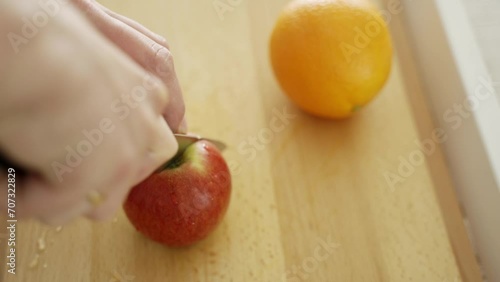 Man cutting an apple on a cutting board