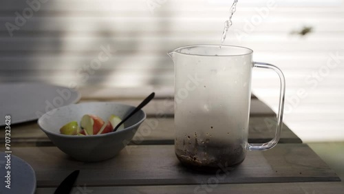 Coffee pouring into a french press outside