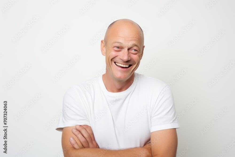 A bald man in a white T-shirt on a white background A bald man in a white T-shirt on a white background