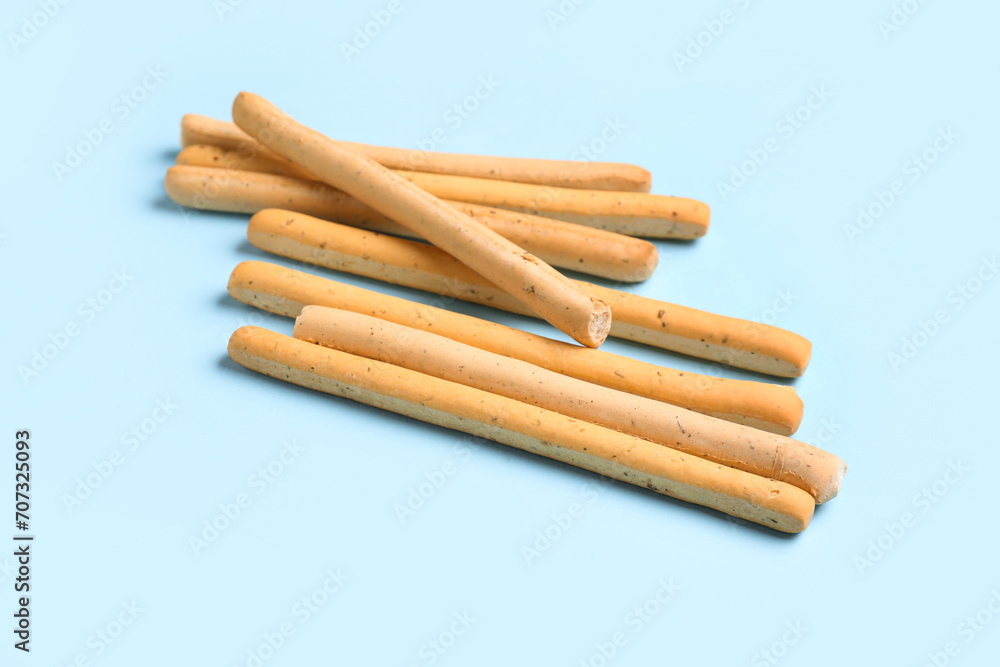 Tasty Italian Grissini on blue background